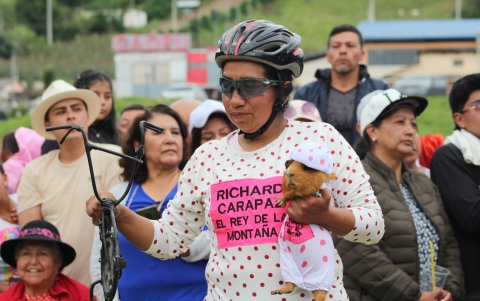 Una mujer sosteniendo un cuy disfrazado del ciclista ecuatoriano Richard Carapaz para rendirle homenaje por su última actuación en el Tour de Francia.