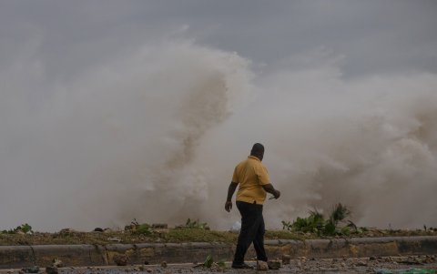 Un hombre observa el fuerte oleaje durante el paso del huracán Beryl.