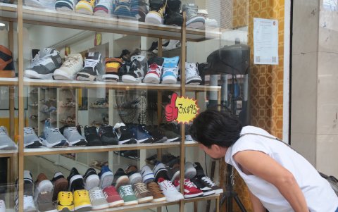 Tienda. Un cliente observa que un par de zapatos cuesta 15 dólares.