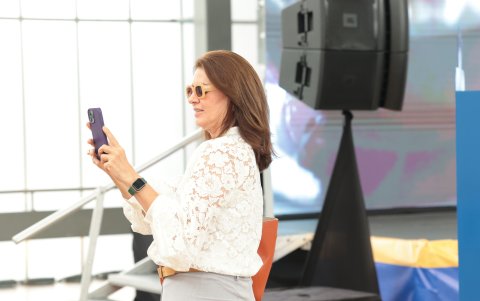 Teresa Arboleda captando el desarrollo del evento con su celular.