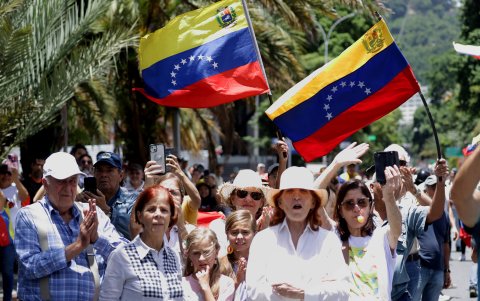 Personas observan a la líder opositora de Venezuela María Corina Machado que asiste a una protesta en rechazo a los resultados oficiales de las elecciones presidenciales