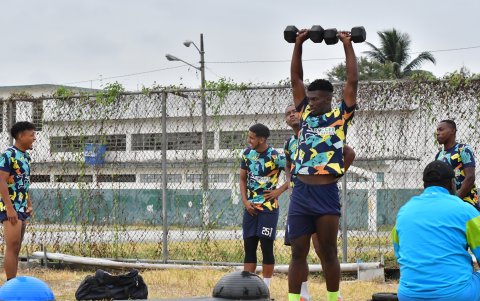 Aris Mina realiza los ejercicios con pesas en el mismo campo de juego que realizan fútbol.
