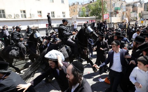 La caballería de la policía intenta dispersar a los judíos ultraortodoxos durante una protesta contra la ley de reclutamiento del ejército.