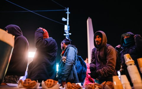 Habitantes de calle reciben alimentos de una fundación.