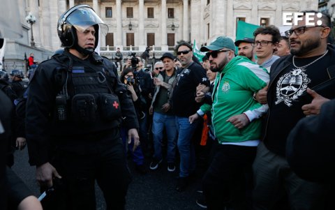 Manifestantes se enfrentan con policías durante una marcha contra el veto presidencial a la ley de jubilaciones.
