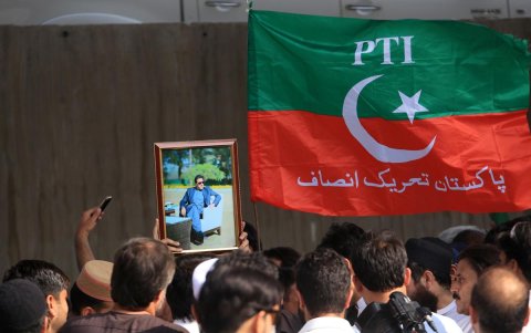 Simpatizantes del partido Pakistan Tehreek-e-Insaf (PTI) sostienen retratos del fundador del partido.