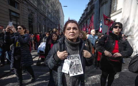 Integrantes de agrupaciones de derechos humanos participan durante el acto conmemorativo a 51 años del golpe militar, frente a la puerta de Morandé 80, este miércoles en Santiago (Chile).
