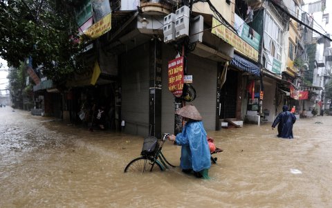 Un residente local camina con una bicicleta por las aguas de la inundación en una calle de Hanoi, Vietnam, el 11 de septiembre de 2024.