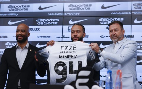 Memphis Depay (c), sostiene la camisa del Corinthians durante su presentación como nuevo jugador del club acompañado del presidente del Corinthians Augusto Melo (d) y el manager Fabio Soldado (i)