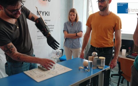 Imagen de uno de las pruebas con la nueva prótesis robótica en la que el paciente vierte agua en un vaso.
