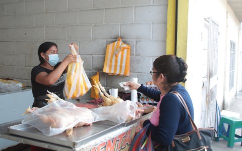 Negocio. En el sector de Los Rosales, en el norte de Guayaquil, Sandra Duchi despacha un pollo despresado a una clienta.