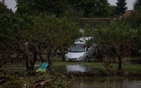 Un automóvil atrapado en las ramas de los árboles en un jardín inundado después del desbordamiento del río Opava tras las fuertes lluvias en el pueblo de Zator, República Checa.