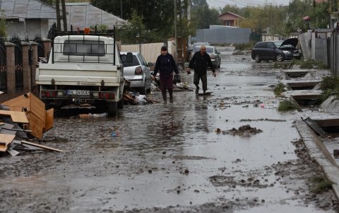 Una pareja rumana se abre camino en una calle embarrada en el pueblo de Pechea, afectado por las inundaciones, cerca de la ciudad de Galati, Rumania, el 15 de septiembre de 2024.