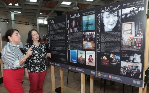 Gina López y María Fernanda Compte observan los afiches de las directoras de cine catalanas que han hecho historia y las láminas del arquitecto modernista Josep Puig i Cadafalch.