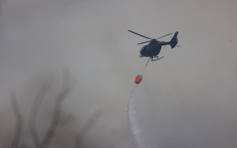 Helicóptero sobrevuela áreas de Quito para mitigar incendio.
