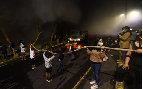 Vecinos de la avenida González Suárez y Manuel Barreto apoyan a las tareas de los bomberos para apaciguar el incendio en el sector Guápulo.