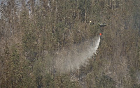 Helicóptero con descargas de agua intenta sofocar el fuego en el Cerro Auqui.