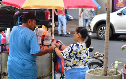 Los transeúntes disfrutan de las carretas y puestos que ofrecen bocados o bebidas a un precio módico, aunque su salubridad sea cuestionada.