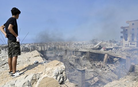 Hombre mira desesperanzado un edificio hecho escombros por el bombardeo israelí.
