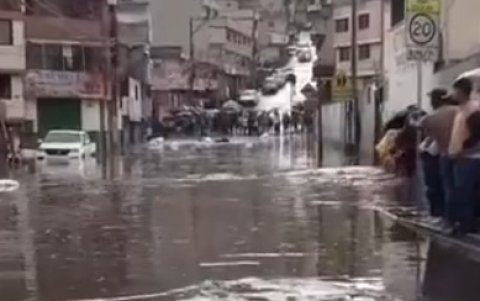 El vehículo quedó atrapado en el agua que se acumuló en una vía de Caupicho, tras la fuerte lluvia en Quito.