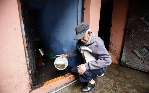 Dolor. Con baldes los vecinos también ayudaban a sacar el agua de las casas. El caudal se llevó todo lo que había a su paso.