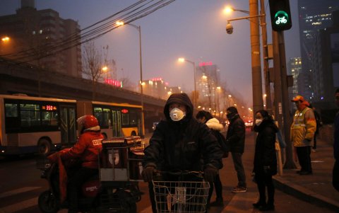 Peatones utilizan mascarillas para protegerse de la contaminación en Pekín (China).