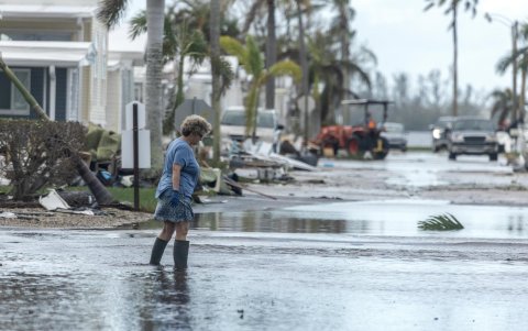 Una mujer camina por una calle inundada tras el paso del huracán Milton.