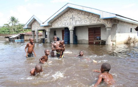 Varios niños juegan en una calle inundada en Ughelli, en el delta del Níger, Nigeria.