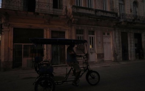 Un bicitaxi que transita por una calle poco iluminada el 26 de marzo de 2024, en La Habana (Cuba).