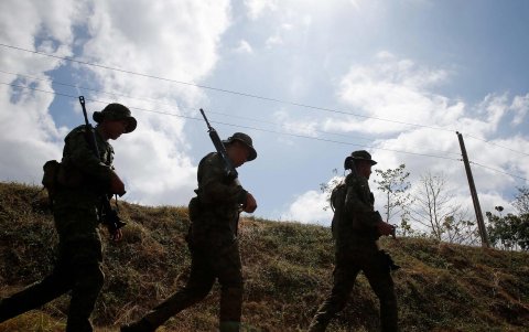 Un grupo de militares filipinos recorren una zona montañosa.