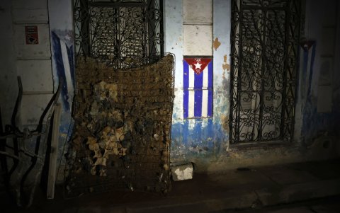 Fotografía de un colchón dañado junto a una bandera de Cuba durante un apagón este viernes, en La Habana.