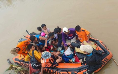 Un grupo de personas son trasladadas a una zona segura tras ser rescatadas por los guardacostas.