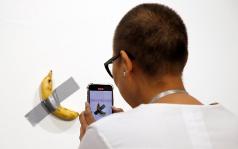 Una persona toma una fotografía de la obra 'Comedian', del artista italiano Maurizio Cattelan, durante el Art Basel en Miami, EE.UU., el 5 de diciembre de 2019.