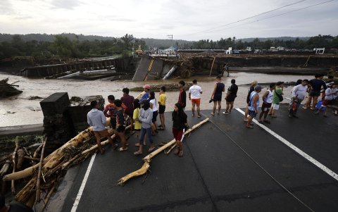 Vecinos observan este viernes un puente dañado en la localidad de Laurel, en la provincia de Batangas, tras el pasado de la tormenta tropical Trami.
