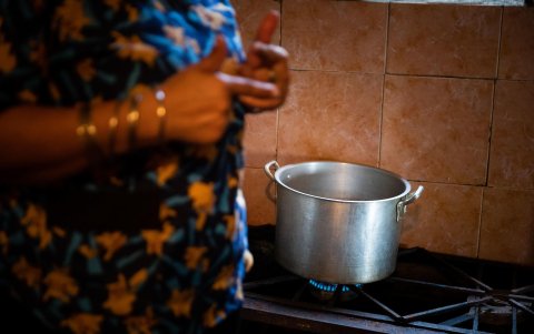 Una persona enciende una cocina a gas en un hogar no determinado.