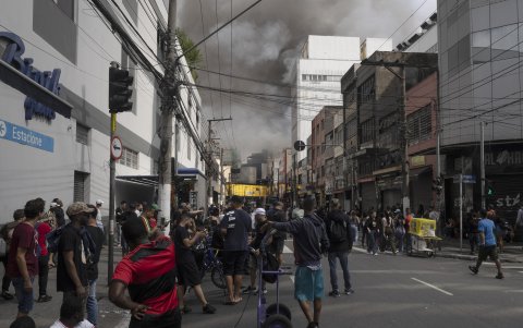 Decenas de personas se amontonan para observar el incendio que afectó el edificio Shopping 25 de Marzo, ubicado en Brás, zona comercial de la ciudad, este miércoles, en Sao Paulo (Brasil).