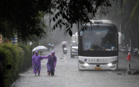 Don personas se trasladan en una zona inundada. El tifón provocó intensas lluvias en la mayor parte de la isla.