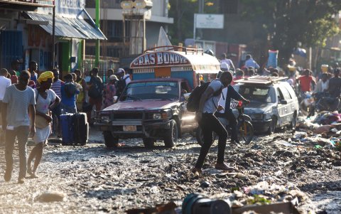 Vehículos y personas transitando por una calle en Puerto Príncipe (Haití).
