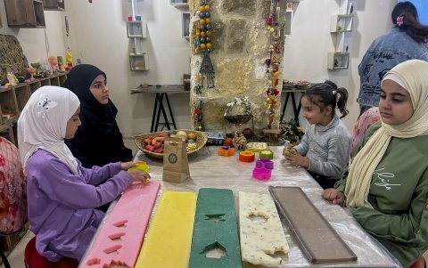 Un grupo de niñas, hijas de familias desplazadas del sur del Líbano, participan en un taller para dar forma al jabón artesanal.