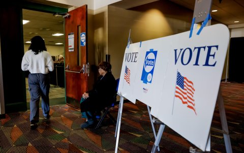 Los votantes participan en la votación anticipada en el Greensboro Coliseum mientras sus partidarios se reúnen afuera para escuchar a Donald Trump.