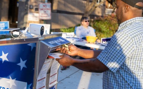 Un votante entrega su boleta de voto por correo en una urna designada en Filadelfia, Pensilvania.