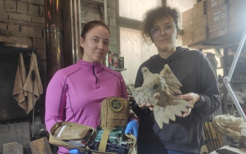 La restauradora Olena Savchuk (i) sostiene un kit médico mientras Ania Kudzia (d) muestra una de las esculturas que está siendo restaurada