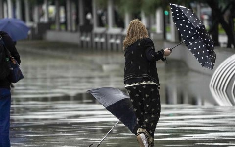 Una mujer se intenta proteger de la fuerte lluvia y el viento con un paraguas, en una imagen de archivo.