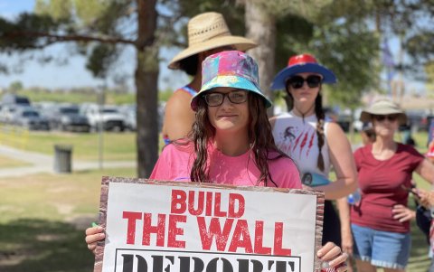 Una mujer con un cartel antimingrantes durante un evento de campaña de Donald Trump.