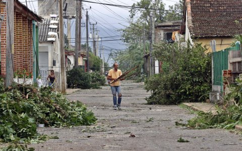 Un hombre recoge escombros en una calle tras el paso del huracán Rafael, este jueves la provincia de Artemisa (Cuba).