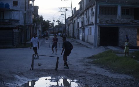 Varios jóvenes juegan fútbol durante un apagón.