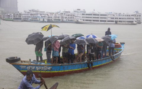 Una embarcación atraviesa un río en un día de lluvias torrenciales en Bangladesh.