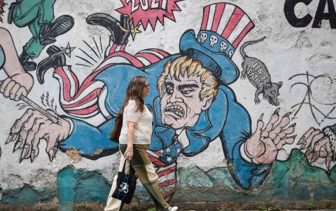 Una mujer camina frente a un mural con un dibujo alusivo a Estados Unidos este miércoles, en Caracas (Venezuela).