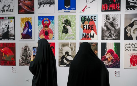 Dos mujeres durante la visita a la exposición internacional de ilustraciones que recrea el horror de la guerra en Palestina.