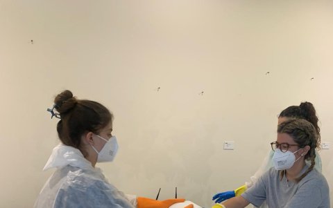 Unas voluntarias secan algunas de las obras arte mojadas en la localidad española